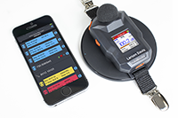 Spartan 730IS Dosimeter Charging on Pad next to Phone with LD Atlas App